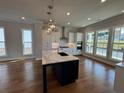 Modern kitchen featuring an island with white countertop, stainless steel appliances, and lots of natural light at 173 Basil St, Cumming, GA 30040