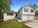 Charming two-story home with a white brick facade and a two-car garage and black shutters at 2067 Wellborn Close, Lithonia, GA 30058