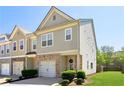 Charming two-story townhome features a brick facade, gray siding, manicured lawn and attached garage at 4925 Longview Walk, Decatur, GA 30035