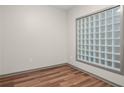 Bedroom view featuring stylish wood floors and natural light from unique glass block window at 390 17Th Nw St # 5008, Atlanta, GA 30363