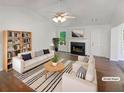 Bright, modern living room with neutral decor, fireplace, and hardwood floors, furnished with stylish sofas and a coffee table at 156 Hawthorn Dr, Carrollton, GA 30116