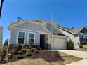 Charming single Gathering home with a two car garage, manicured lawn, and stone details at 186 Sunshower Rdg, Canton, GA 30114