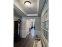 Inviting hallway with wood floors, decorative wainscoting, bench, and view to the living room at 186 Sunshower Rdg, Canton, GA 30114