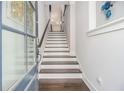 Bright stairway with hardwood steps, white risers, and a stylish glass-paneled door at 289 Heritage Se Ln, Atlanta, GA 30316
