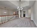 Spacious living room with a modern chandelier, fresh grey carpet and neutral paint at 3681 Auger Trl, Douglasville, GA 30135
