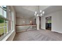 Bright living room with modern chandelier, fresh grey carpet and neutral paint at 3681 Auger Trl, Douglasville, GA 30135