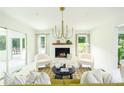 Bright living room featuring a cozy fireplace, modern chandelier, neutral colors, and stylish furnishings at 1662 Rainier Falls Ne Dr, Atlanta, GA 30329