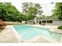 Gorgeous backyard oasis with large in-ground pool, patio, and lush landscaping providing privacy at 1662 Rainier Falls Ne Dr, Atlanta, GA 30329