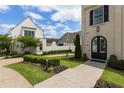 Charming two-story home featuring a manicured lawn and an elegant arched doorway at 316 S Esplanade, Alpharetta, GA 30009