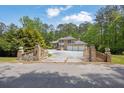 Charming brick gated entrance of a two-story home with a circular driveway at 5302 Greenway Dr, Villa Rica, GA 30180
