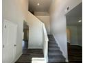 Bright entryway featuring a staircase with gray carpeting and wood-look floors leading to upper level at 142 Tye St, Stockbridge, GA 30281