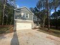 Charming two-story home with a two-car garage and a beautifully landscaped front yard surrounded by mature trees at 142 Tye St, Stockbridge, GA 30281