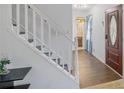 Bright foyer with wood-look flooring, white staircase, and view of the main bathroom at 2100 Ann Se Ct, Conyers, GA 30013