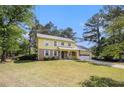Inviting two-story home with yellow siding, stone accents, front porch and attached garage at 2100 Ann Se Ct, Conyers, GA 30013