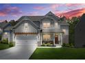 Stunning two-story home with an inviting front porch and beautiful landscaping under a vibrant sunset sky at 410 Crestbrook Ln, Dallas, GA 30157