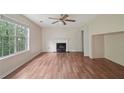 Bright living room featuring hardwood floors, a cozy fireplace, and large windows at 7117 Stonebrook Cv, Lithonia, GA 30058
