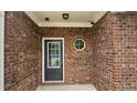Close-up of the brick-lined front porch, featuring a black door with a window and unique octagon window at 1529 Iris Walk, Jonesboro, GA 30238