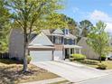 Two-story home boasts a spacious driveway, attached two-car garage, and a beautifully maintained lawn at 1657 Preserve Park Dr, Loganville, GA 30052
