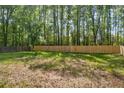 Large, grassy backyard surrounded by tall trees, perfect for outdoor activities at 1660 Rose Garden Ln, Loganville, GA 30052