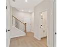 Bright hallway with wood floors, a staircase, access to a half bathroom, and doors to other rooms at 1995 Deco Dr, Kennesaw, GA 30144