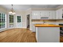 Bright kitchen features white cabinets, a butcher block island, hardwood floors and stainless steel appliances at 3171 Blairhill Ct, Atlanta, GA 30340