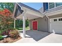 An eye-catching red door nestled within a welcoming carriage and beautiful landscaping at 5800 Villa Rica Hwy, Dallas, GA 30157