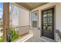 Close-up of front porch with brick accents, iron railings, and a stylish dark-stained front door with glass panels at 1225 Westshore Dr, Cumming, GA 30041