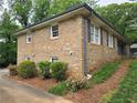 Side view of the home with brick facade, traditional windows, and well-manicured landscaping at 1810 Trophy Dr, Marietta, GA 30062