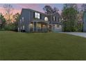 Two-story brick home with a covered porch and attached garage on a grassy lot at dusk at 2055 Deans Landing Dr, Lawrenceville, GA 30043