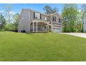 Inviting two-story brick home featuring a covered porch and an attached garage surrounded by a lush green lawn at 2055 Deans Landing Dr, Lawrenceville, GA 30043