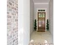 Inviting entryway features a wood door with sidelights, topiaries, and brick accents at 2801 Avington Se Ln, Smyrna, GA 30080