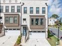 Close-up of a modern townhome with white brick, bay windows, and an attached garage showcasing a clean design at 2171 Burnside Dr Nw, Atlanta, GA 30318