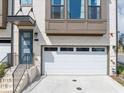 A modern townhouse, with a one-car garage, painted white with black trim, and blue front door at 2171 Burnside Dr Nw, Atlanta, GA 30318