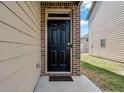 Close-up of the home's front door entrance, with tan siding and brick trim at 2631 Lovejoy Crossing Dr, Hampton, GA 30228