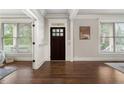 Elegant foyer featuring hardwood floors, white trim, and a dark wood front door at 1165 Victoria Ne St, Brookhaven, GA 30319