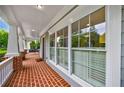 Spacious front porch with red brick flooring, white columns, and views of the surrounding greenery at 1349 Middlesex Ne Ave, Atlanta, GA 30306