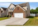 Spacious driveway leading to a two-car garage with a well-maintained lawn and partial fencing at 2267 Clapton Ct, Jonesboro, GA 30236