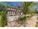 Beautiful two-story home with a manicured lawn, picket fence, and lovely landscaping at 2406 Glenwood Ne Dr, Atlanta, GA 30305