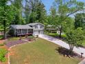 Beautiful view of the home's exterior, showcasing the lawn and driveway, complemented by surrounding trees at 4124 Dunnington Dr, Marietta, GA 30062