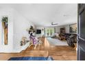 Bright living room with wood floors, a stone fireplace, modern ceiling fan, and access to the outdoor space at 5742 Harbor Dr, Buford, GA 30518