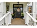 Inviting front door with a decorative wreath and matching flower pots on a charming wooden porch at 1161 Arborhill Dr, Woodstock, GA 30189