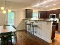 Open kitchen with hardwood floors, modern appliances, and breakfast bar at 702 Emeril Dr, Avondale Estates, GA 30002
