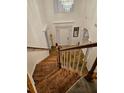 Staircase with a wood handrail and white balusters, offering a view of the light-filled foyer below at 4299 Sherwood Oaks Dr, Decatur, GA 30034