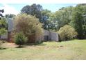 Large, grassy backyard with mature trees and a brick chimney, offering a peaceful outdoor space at 3215 Hembry Ct, Marietta, GA 30062