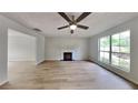 Spacious living room with a cozy fireplace, ceiling fan, large window, and durable wood-look floors for comfort and style at 829 Longfellow Ct, Stone Mountain, GA 30088