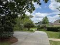 Scenic view of the property with a long driveway and lush landscaping at 2038 Lee Se Rd, Smyrna, GA 30080
