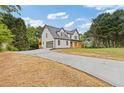 View of home with a long driveway leading to a garage and a covered front porch at 470 Brackin Trce, Grayson, GA 30017