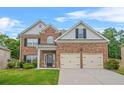 Charming two-story brick home with a well-manicured lawn and a two-car garage at 113 Expedition Dr, Ellenwood, GA 30294