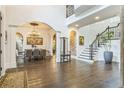 Grand foyer featuring high ceilings, hardwood floors, staircase with railing, dining room, and brick accent wall at 3938 Hillsman Ln, Marietta, GA 30062