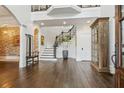 Spacious foyer with hardwood floors, staircase with iron railing, and brick accent wall exudes elegance at 3938 Hillsman Ln, Marietta, GA 30062